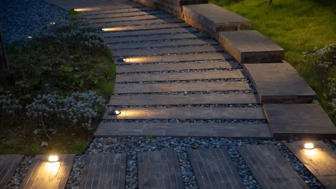 A beautifully landscaped garden at night, illuminated by energy-efficient LED landscape lights