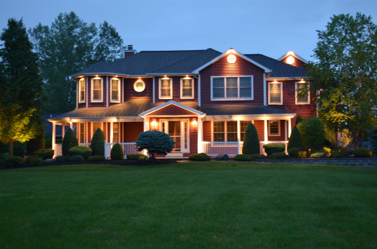 Subtle landscape lighting illuminating a stone retaining wall and pathway at night